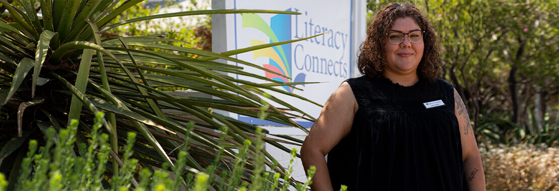 Lupita Vazquez stands smiling outside of Literacy Connects