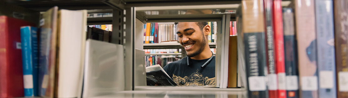Student in the library stacks at Desert Vista campus library