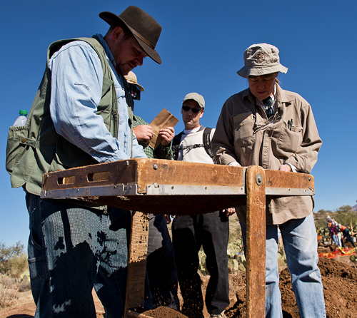 Students sift through gravel at a site in attempt to find artifacts