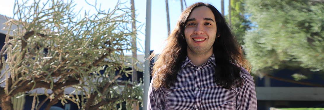 Dario Mendoza stands Smiling on Pima West Campus