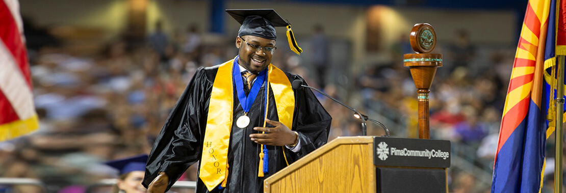 Webster Rose walks across stage at Pima's Commencement 2022