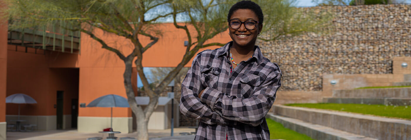 Dominic Fortune stands smiling in a courtyard at Pima's Northwest Campus