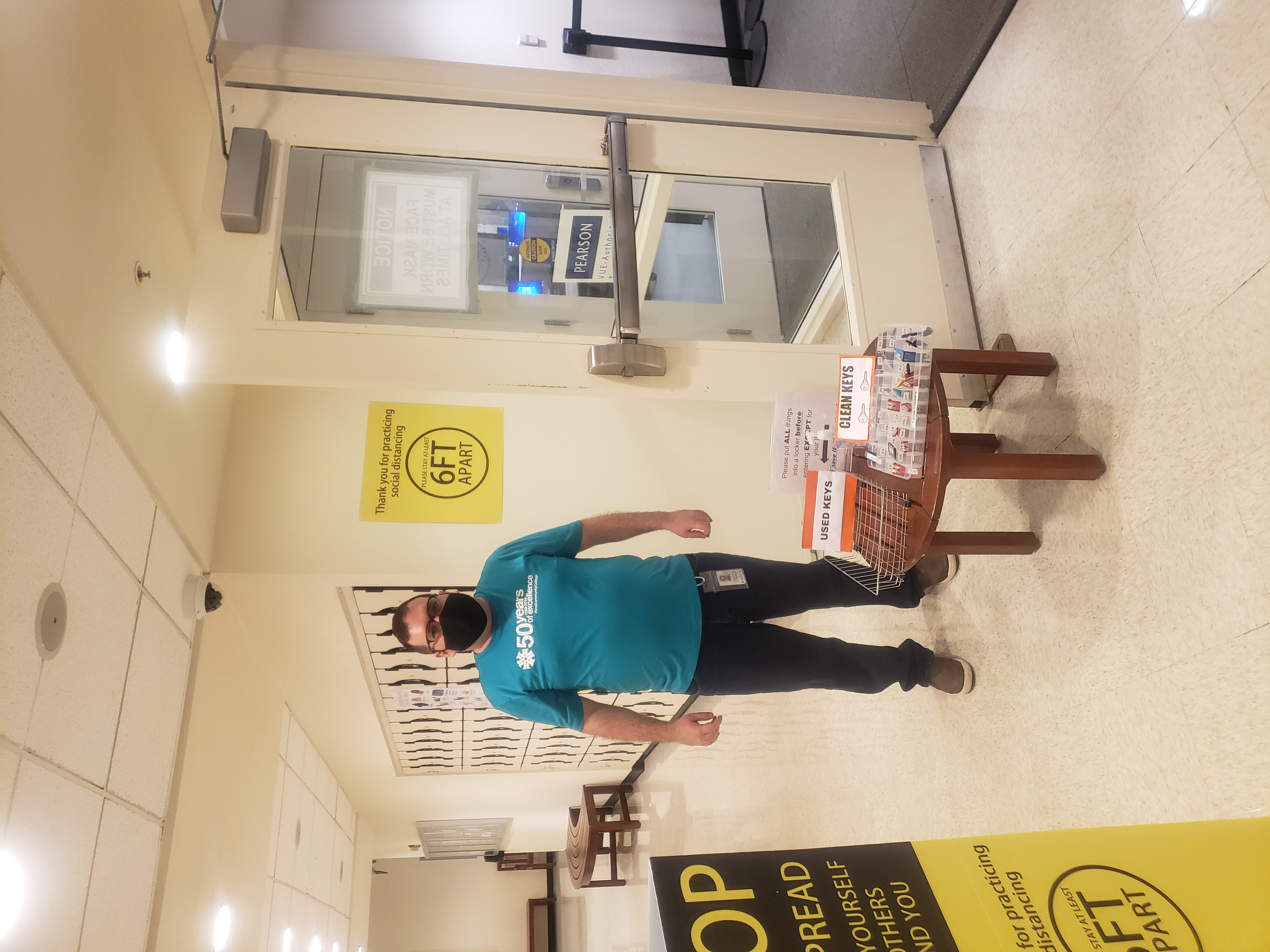 Testing center worker stands in front of door with mask