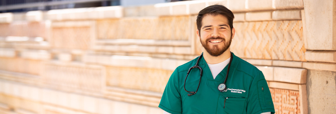 Vinny Jordan smiles on a Pima Campus in scrubs