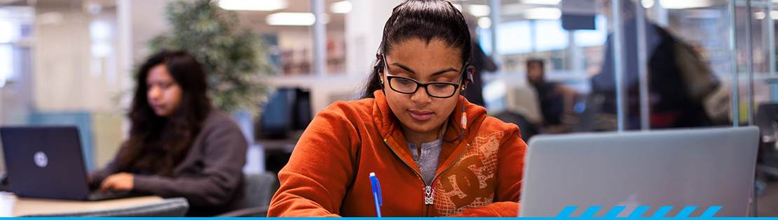 A student does online work with laptop in a library