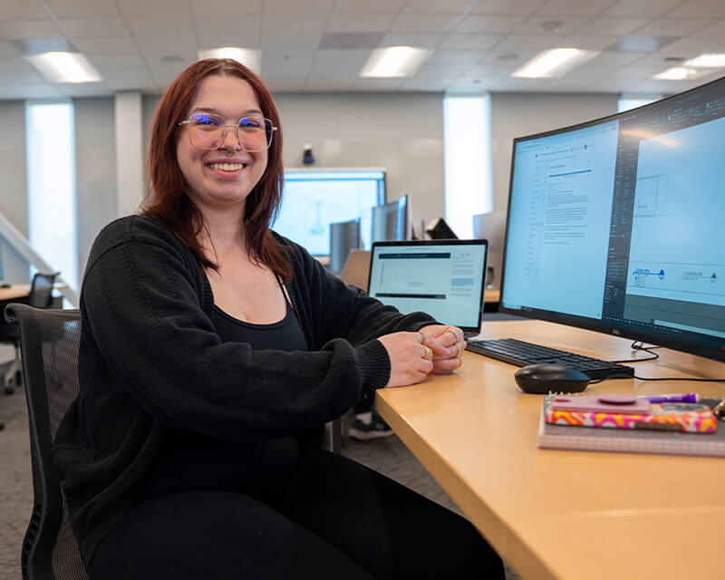 Student sits at a table in the library.