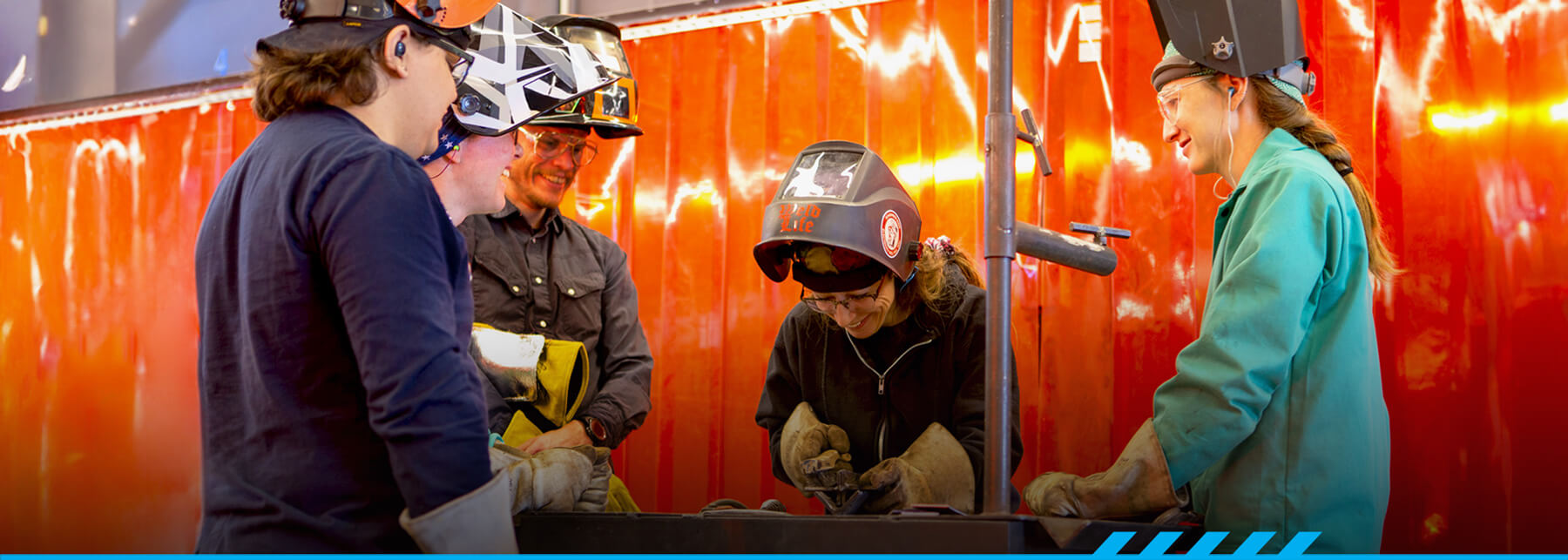 Regina Santaniello teaching students in a welding lab.