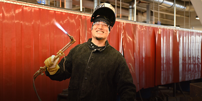Student wearing protective gear works in the welding lab at Pima Community College.