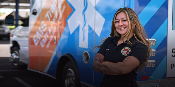 A student poses next to a van with Pima Community College branding.