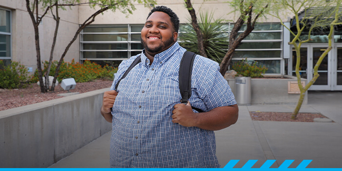 Caleb Bailey poses in front of Pima West Campus main entrance. 