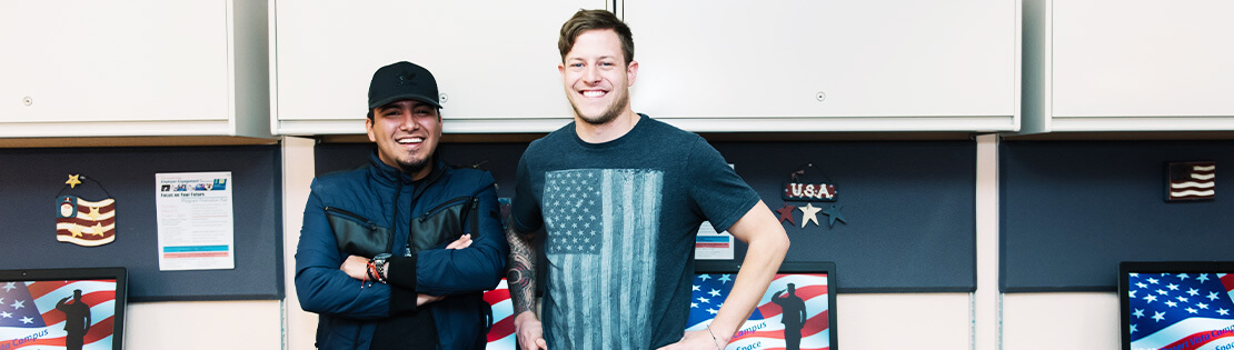 Two Military Students stand smiling in a Veterans Center