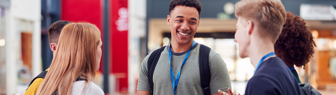 3 students walk and talk in a breezeway at Northwest Campus