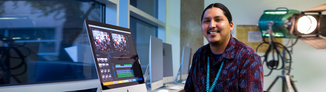 A Digital Arts student works on a video at a computer in a Pima West campus video lab