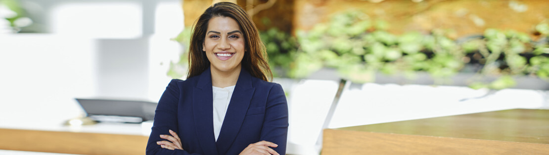 A hotel manager stands posing for the camera outside of a hotel