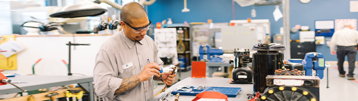 A student works on manufacturing equipment in a Pima Lab