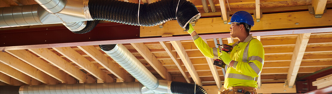 A student inspects some air ventilation in a new build.