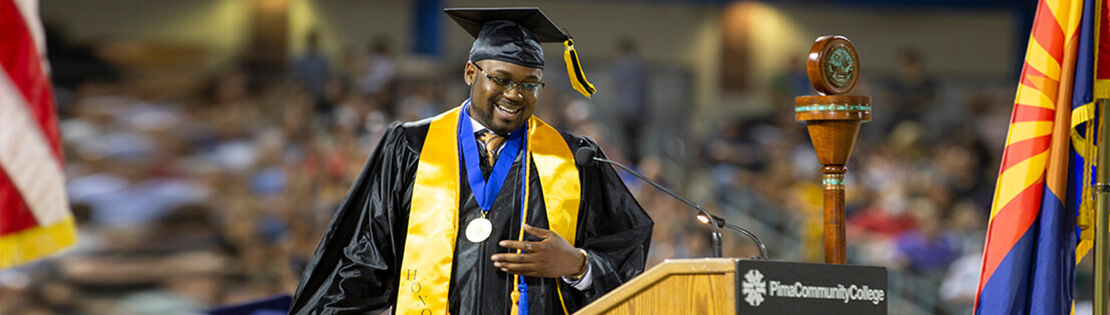 A Pima graduate smiles as he steps down from the podium at Graduation