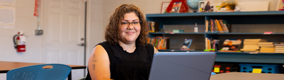 A student works in a Pima library with her laptop