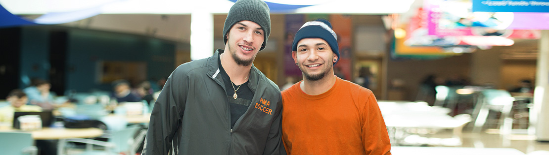 Students pose and smile in a student lounge at West Campus