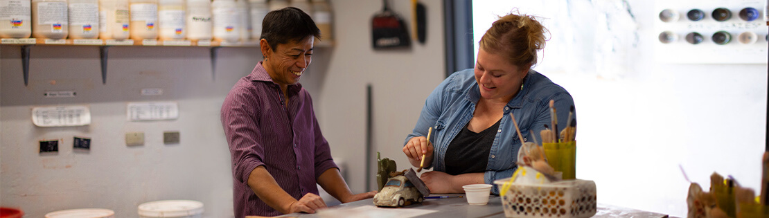 Two Pima students work on some pottery