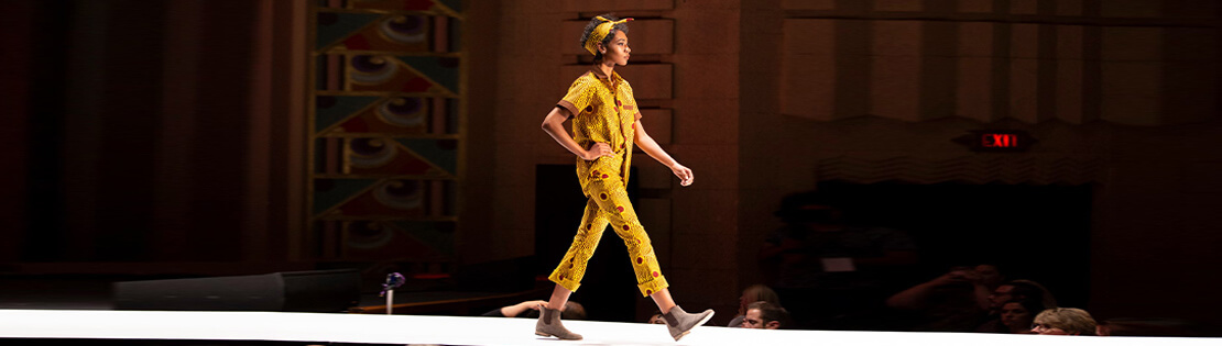 A student walks in a fashion show