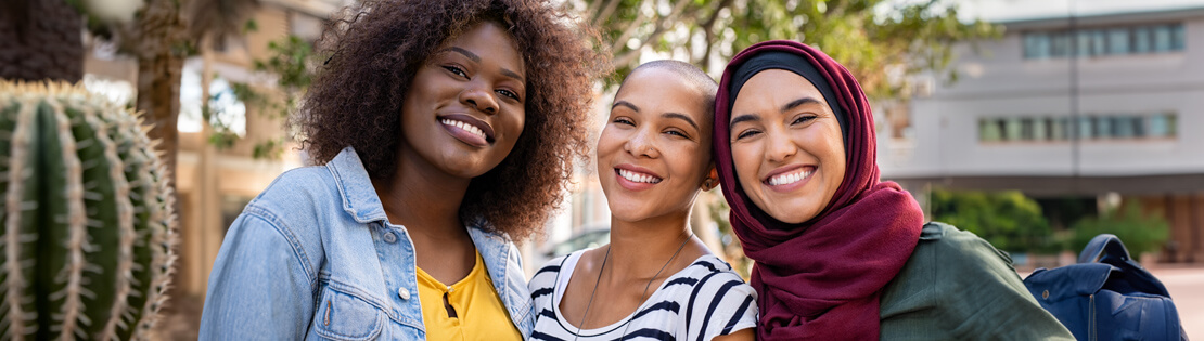 Two international students stand smiling in a Pima Common Area