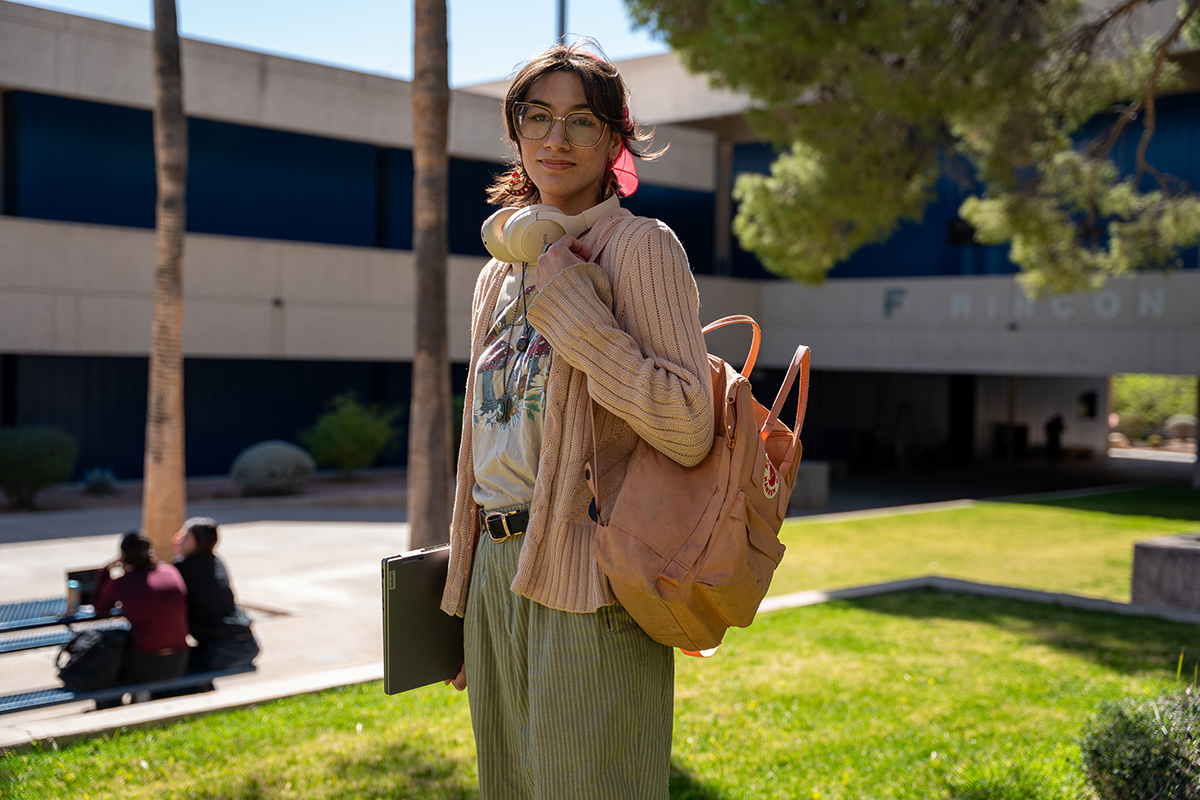 Maia stands smiling in a breezeway at Pima's West Campus