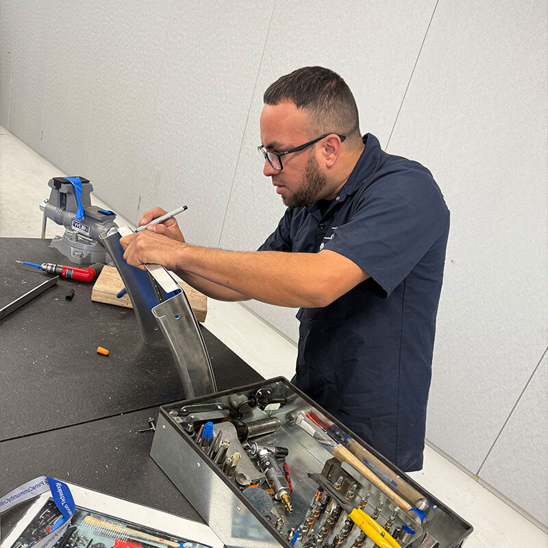Ramsses works on an aircraft part in a lab