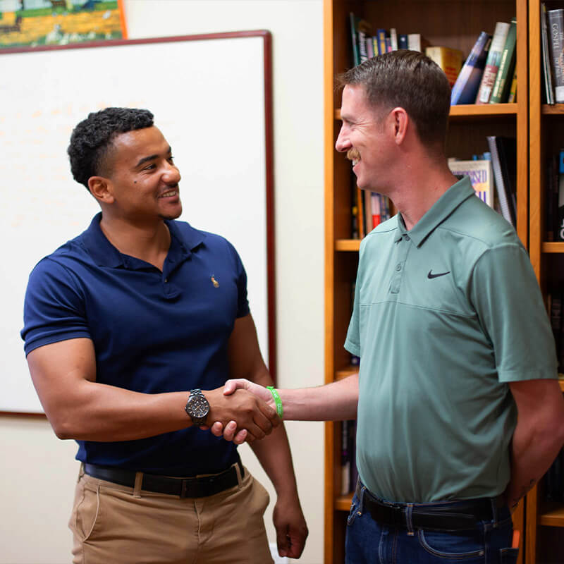 Nick shakes hands with a professor