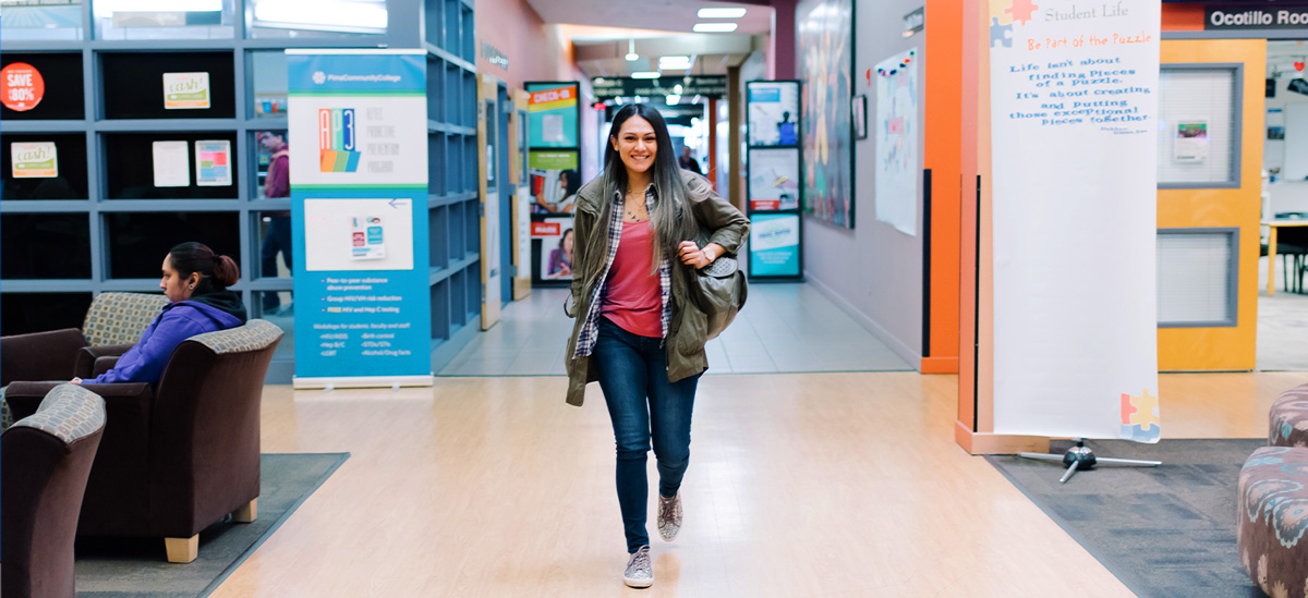 An student walks down a hall at a Pima campus